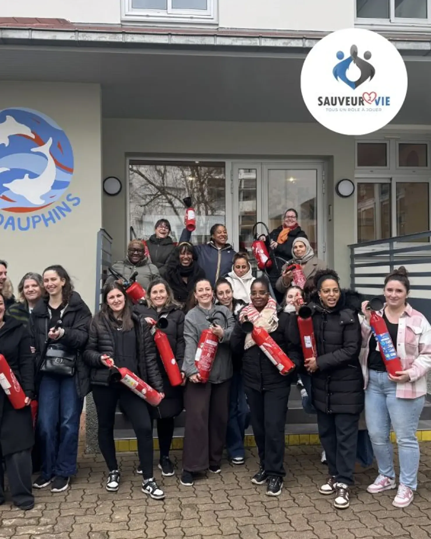 Équipe d’une crèche avec les extincteurs devant leur structure